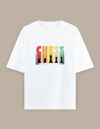 White oversized t-shirt featuring a colorful vintage "CHESS" graphic with classic chess piece silhouettes printed on the front.