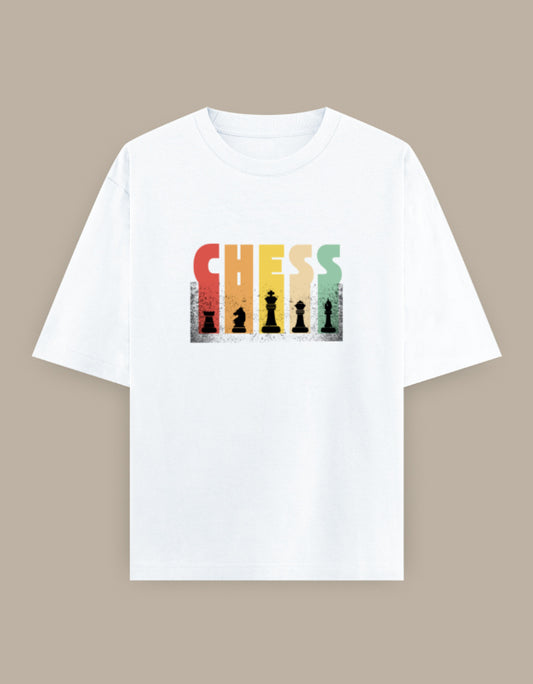 White oversized t-shirt featuring a colorful vintage "CHESS" graphic with classic chess piece silhouettes printed on the front.