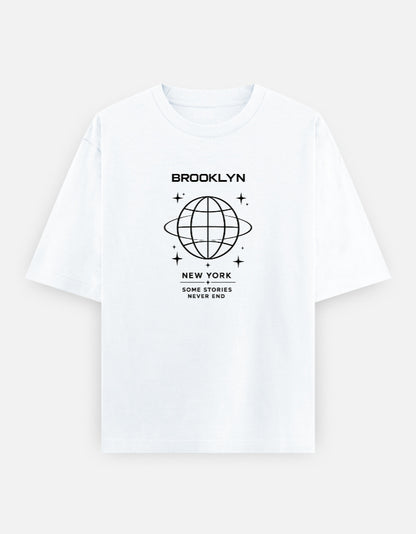 White oversized t-shirt featuring a minimalist Brooklyn New York graphic with a geometric globe illustration and the phrase "Some Stories Never End" printed on the front.