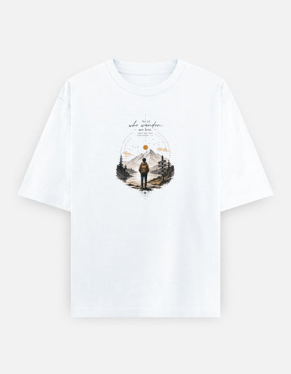 White oversized t-shirt featuring a minimalist mountain landscape with a traveler illustration and the inspirational quote "Not all who wander are lost" printed on the front.