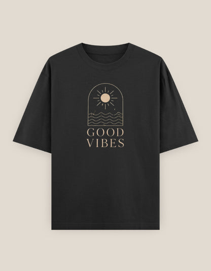 Black oversized t-shirt featuring a minimalist sun and ocean line-art graphic with "Good Vibes" typography printed on the front.