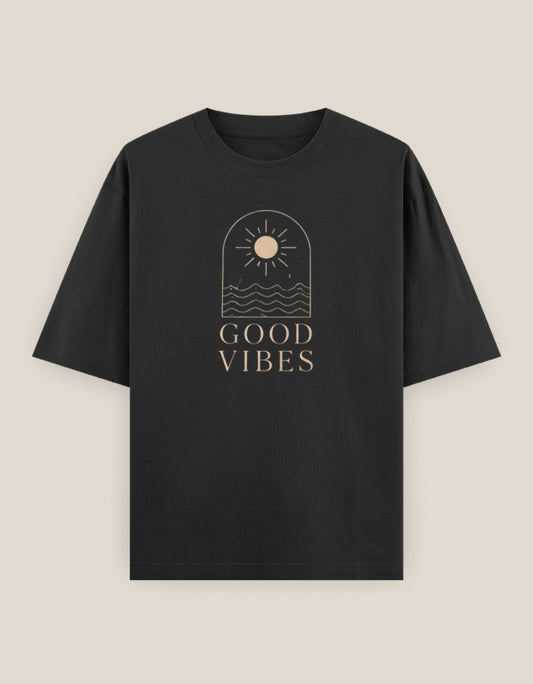Black oversized t-shirt featuring a minimalist sun and ocean line-art graphic with "Good Vibes" typography printed on the front.