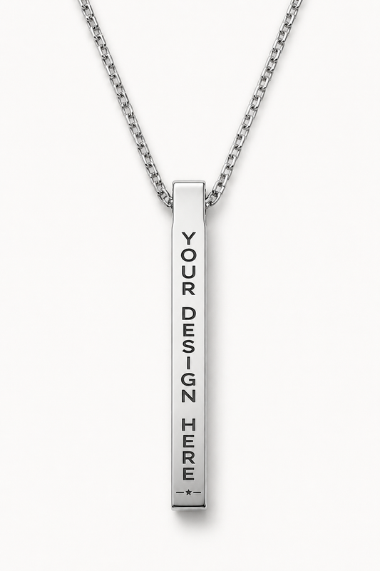 A silver vertical bar necklace with a chain, featuring the text 'YOUR DESIGN HERE' printed vertically in black on the bar, set against a light gray background.